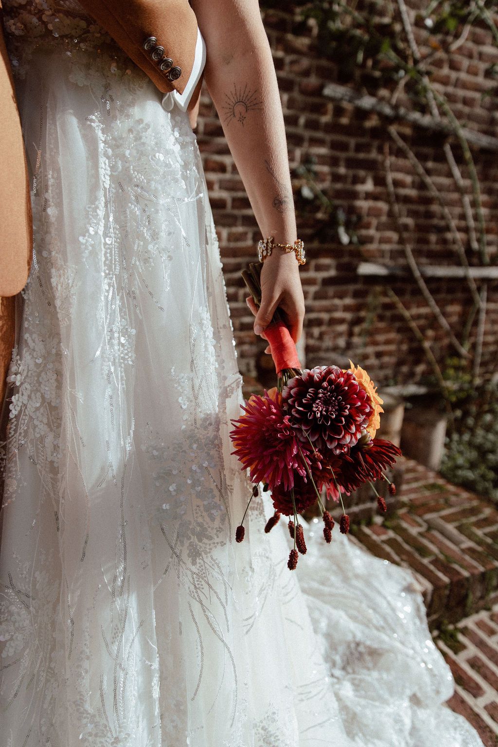10. Real bride Mandy Gout straalt in haar trouwjurk met sprankelende details en kleurrijk bruidsboeket.