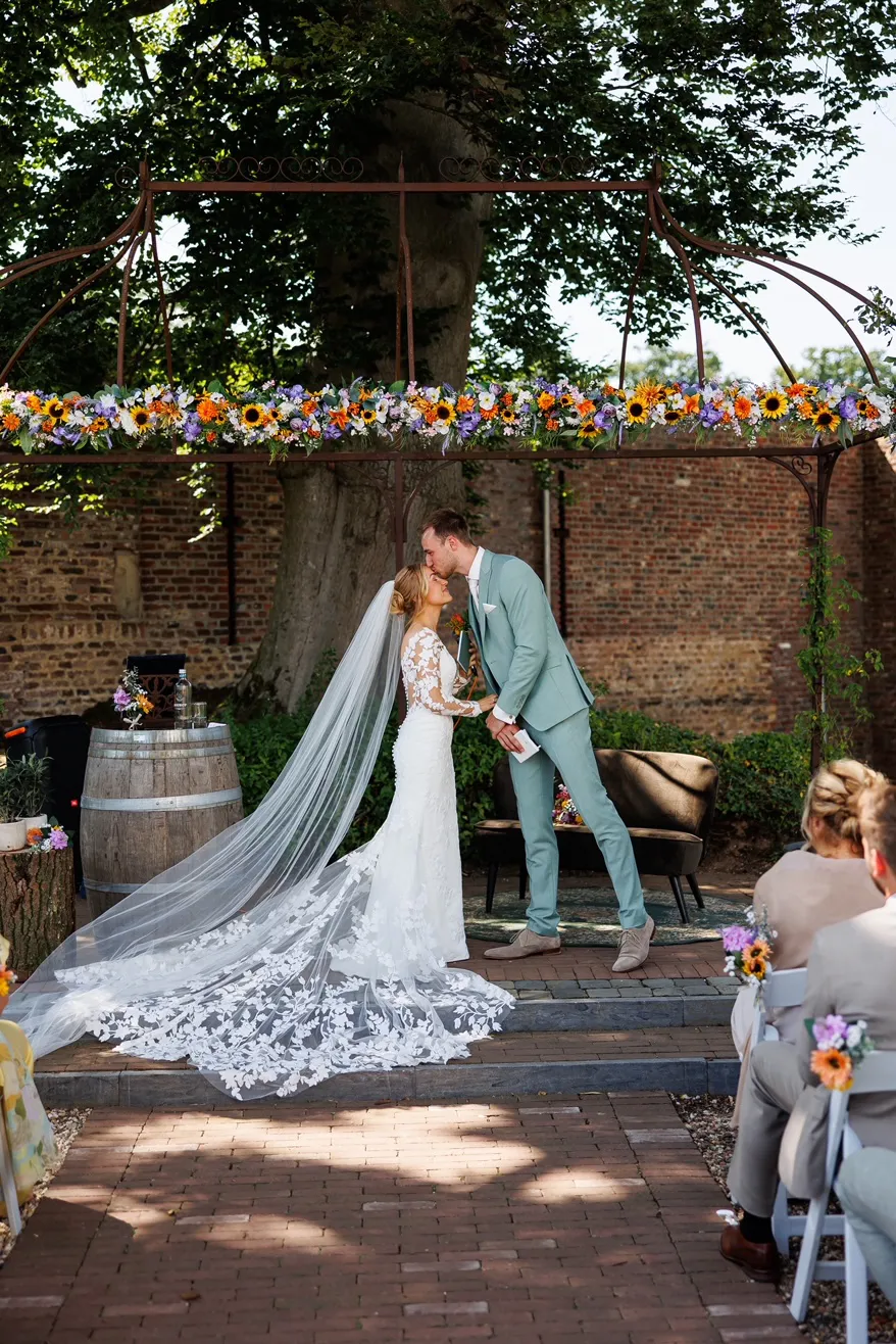 real-bride-review-fenna-van-gerven-bruidshuis-diana bruid Fenna van Gerven tijdens buiten ceremonie in kanten zeemeermin trouwjurk met lange sluier 