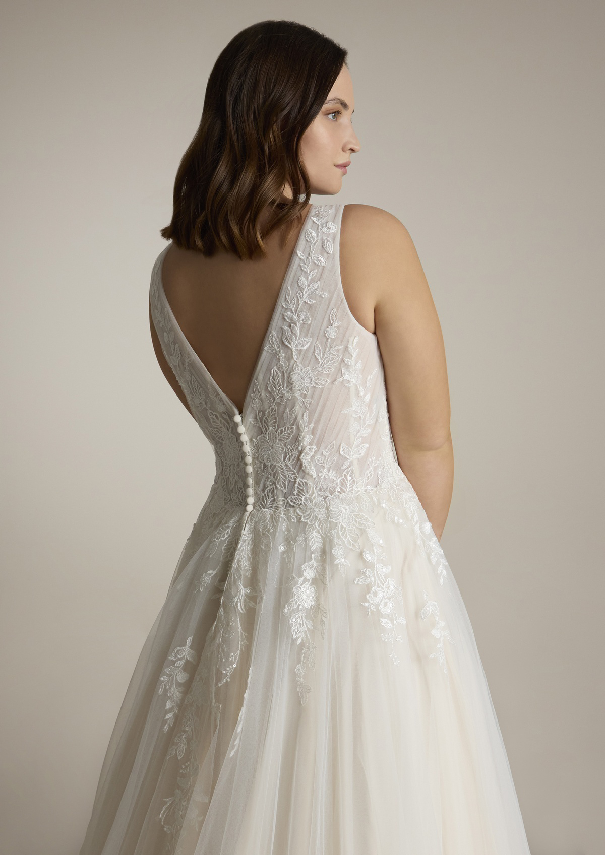 Trouwjurk met lage rug Sugon van Ladybird. Achteraanzicht van de A-lijn met kanten details en picpac knoopjes.