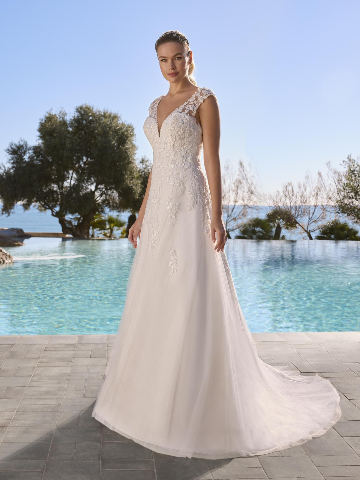 A-lijn trouwjurk Blomster van Ladybird met kanten kapmouwtjes en V-hals. Vooraanzicht van deze romantische bruidsjurk.