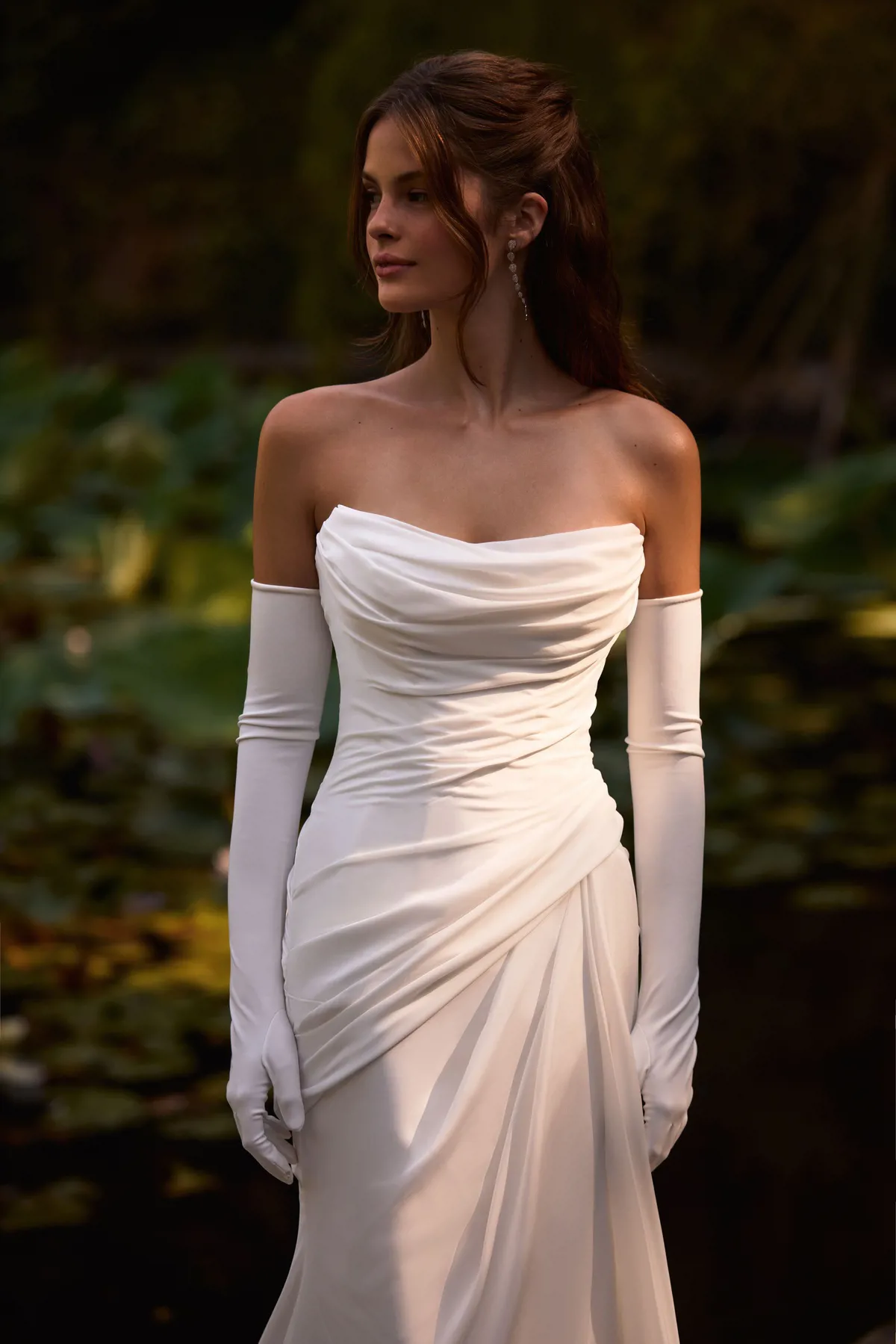 Milla Nova trouwjurk Amika, strapless satijnen zeemeerminjurk met mouwen en gedrapeerde bodice, bruid bij vijver in tuin