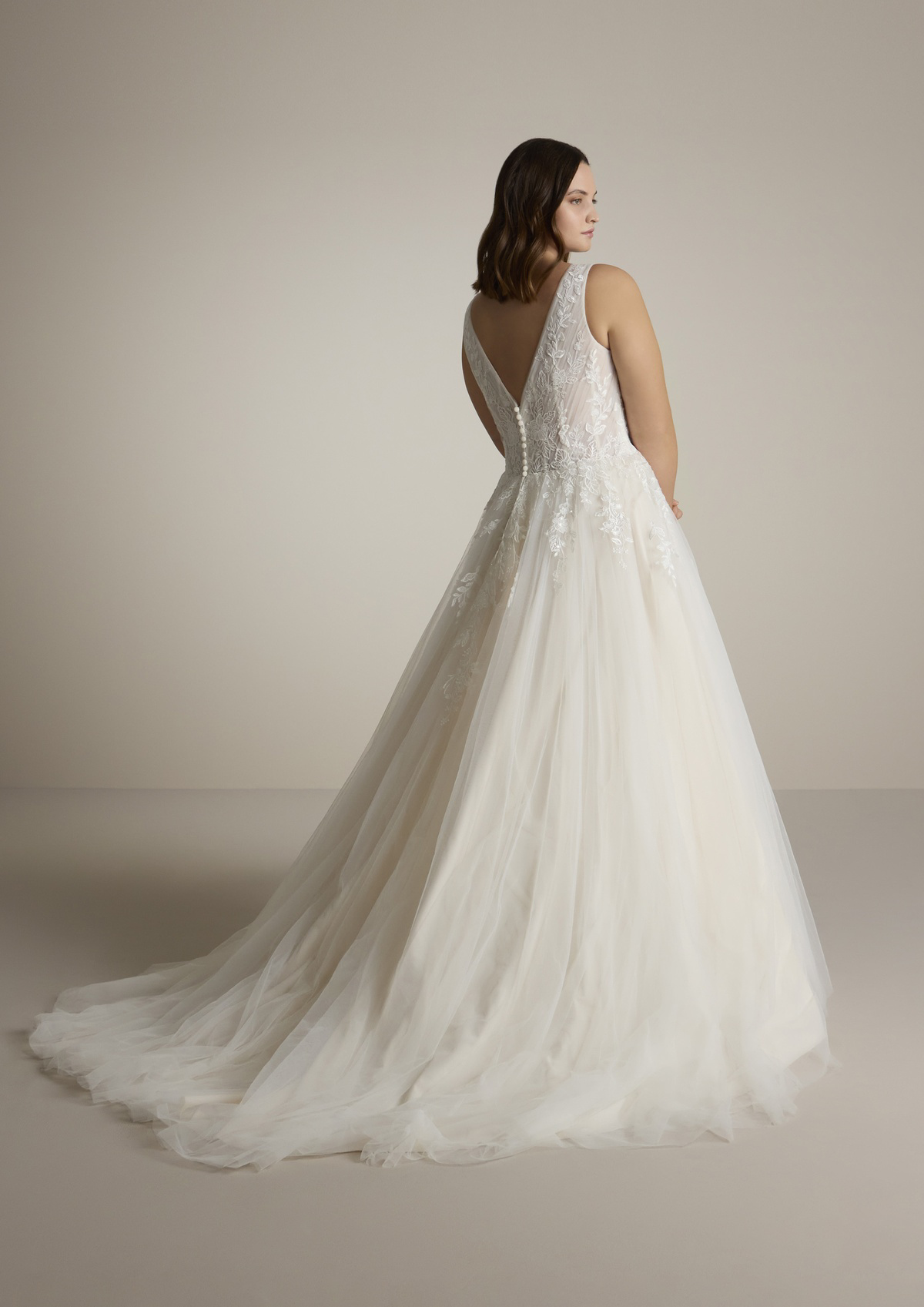 Trouwjurk met lage rug Sugon van Ladybird. Achteraanzicht van de A-lijn jurk met kanten top en picpac knoopjes.